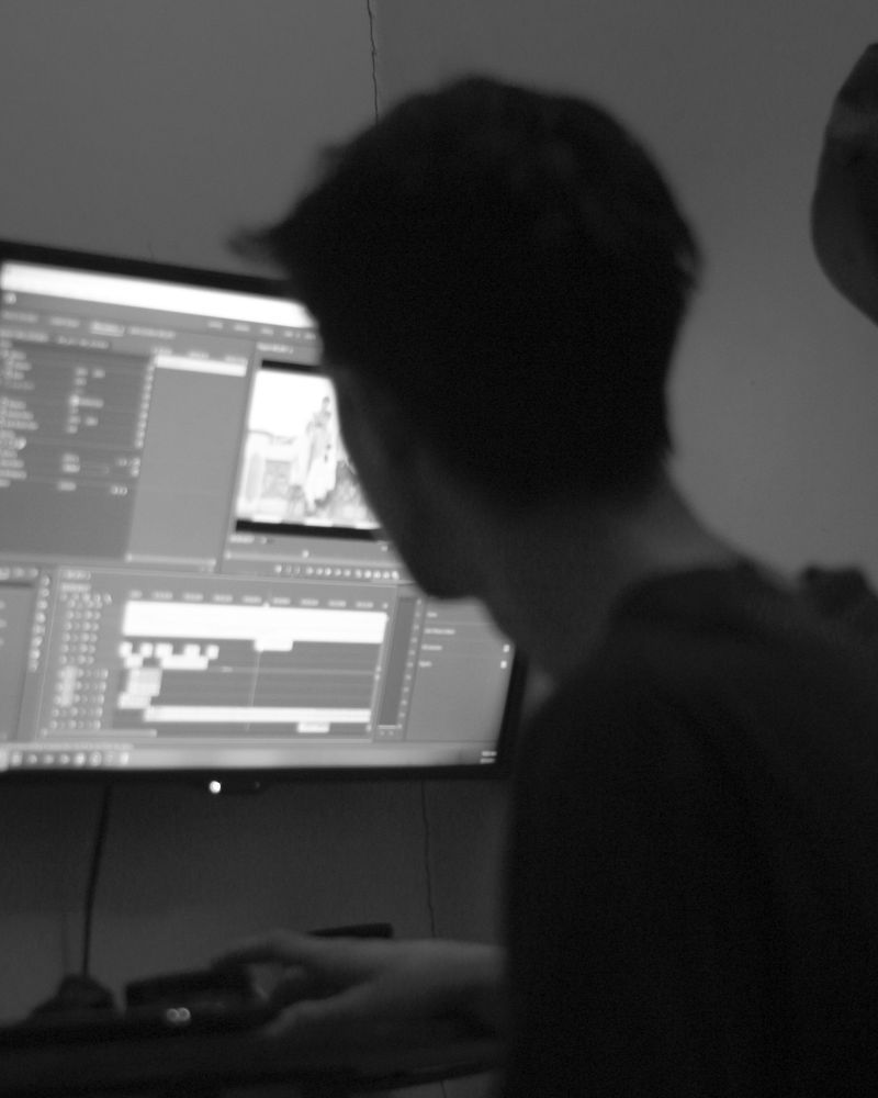 Seen from behind, an analyst working at a monitor in a dim room